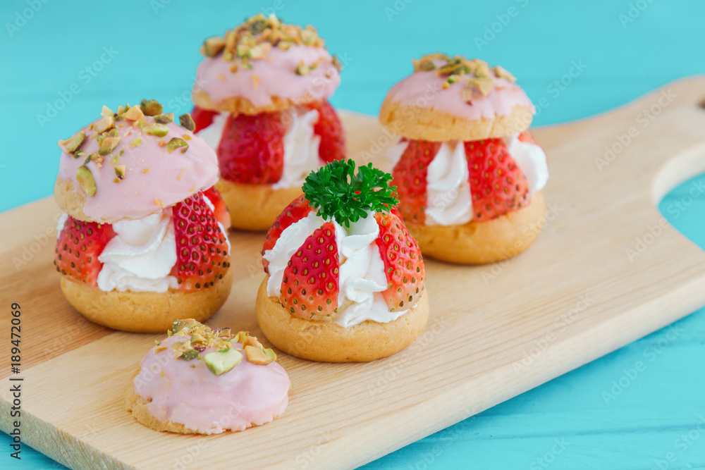 Strawberry choux cream. Combination with choux pastry whipped cream fresh strawberries glaze with white chocolate and chopped pistachios. Sweet and delicious dessert for Valentine. Homemade bakery.