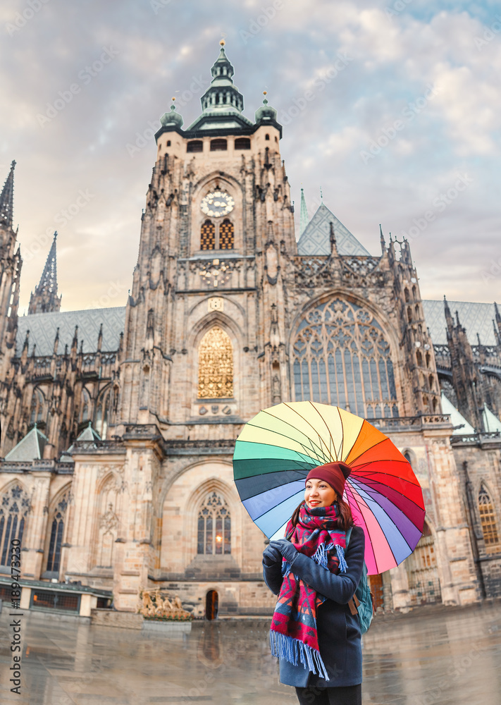 Woman traveler with umbrella near great St. Vitus Cathedral in Prague, Czech Republic