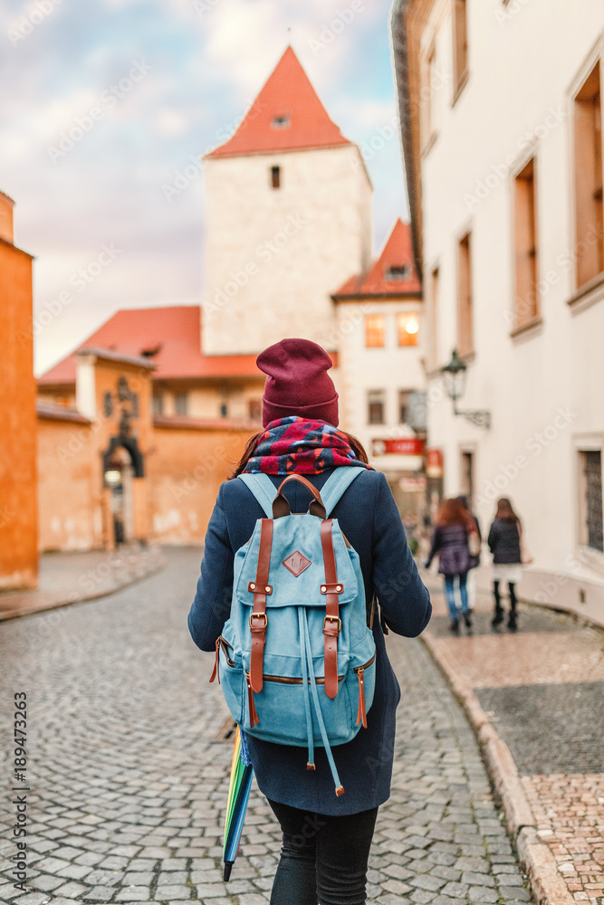 rear view of a traveler woman with backpack looking at historical architecture, sightseeing tour concept rear view of a traveler woman with backpack looking at historical architecture, sightseeing tour concept