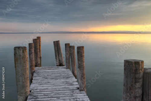 Wooden Pier with Columns on the Lake at Sunset © kaycco