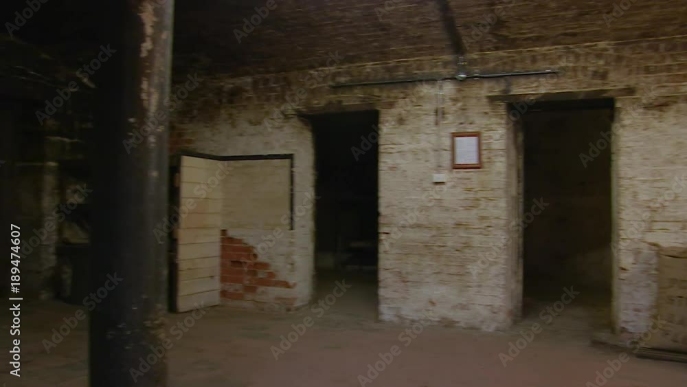 A medium shot of a dungeon with a door. Camera pans to the left A medium shot of a dungeon with a door. Camera pans to the left