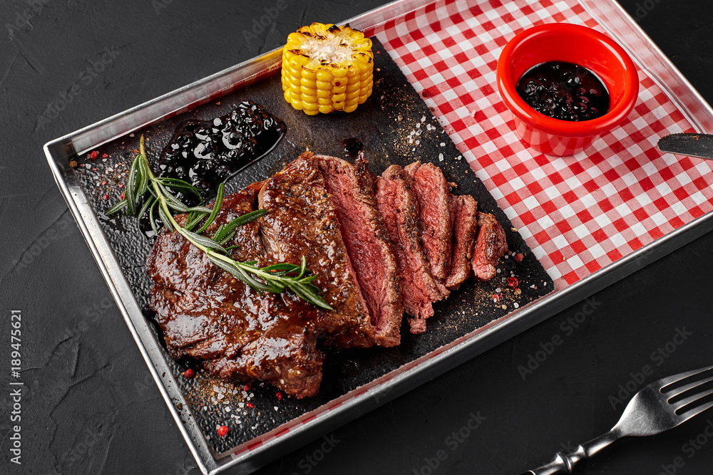 Cut into several pieces of roasted beef tenderloin with herbs, baked corn and rosemary-currant sauce. Top view Cut into several pieces of roasted beef tenderloin with herbs, baked corn and rosemary-currant sauce. Top view