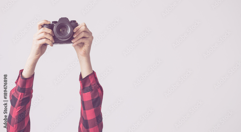 Young female, raised up arms and holding camera isolated background - obrazy, fototapety, plakaty 