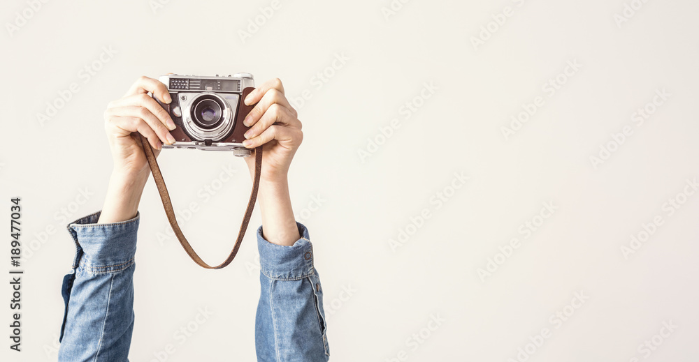 Arms up holding vintage camera isolated background