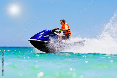 Billede på lærred Teenager on jet ski. Teen age boy water skiing.
