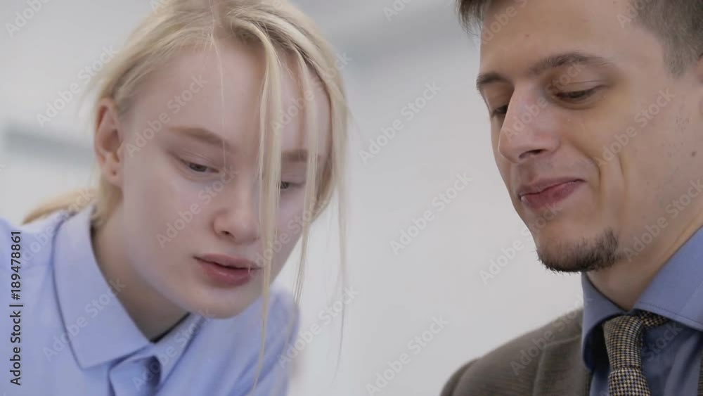 Portrait of a man and a woman who look at one object together. Close-up people with interest peer at screen and smile from view. Portrait of a man and a woman who look at one object together. Close-up people with interest peer at screen and smile from view.