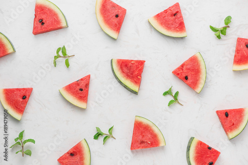 Watermelon slices, green mint leaves on white background. Top view, flat lay.