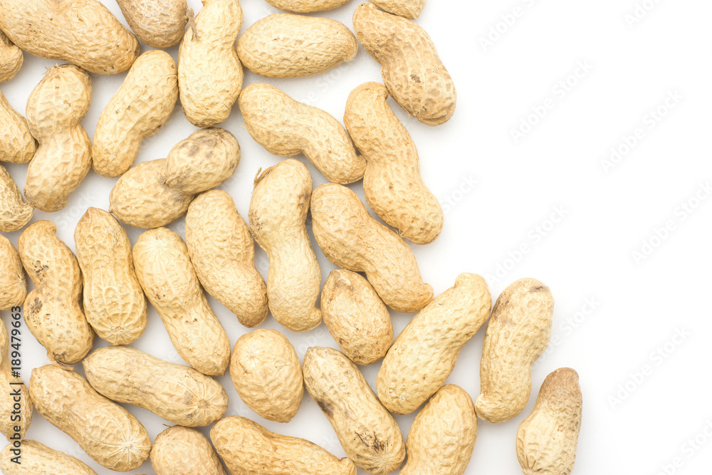 Unshelled peanuts top view isolated on white background left side. Unshelled peanuts top view isolated on white background left side.