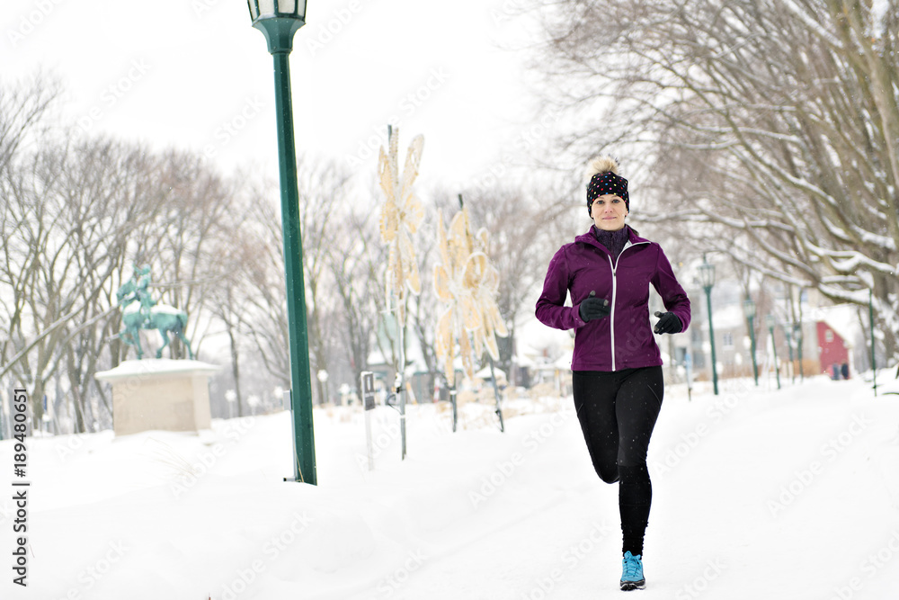 Woman Running in Snowy Park in winter season