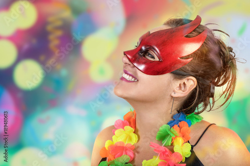 Girl having fun jumping and dancing carnival with mascara necklace of flowers and fan at a party
