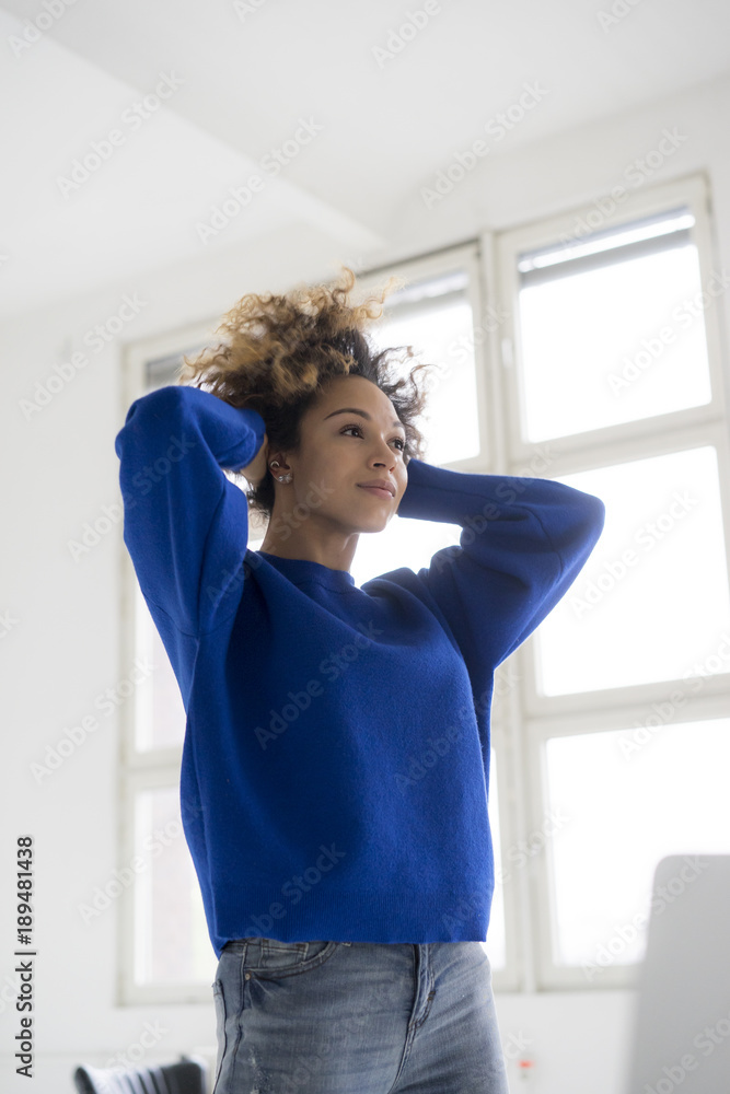 Portrait of young woman doing stretching exercise in office Portrait of young woman doing stretching exercise in office