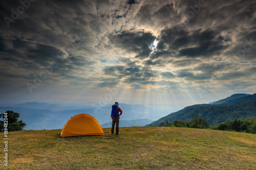The hiking man and camping tents on the mountain.