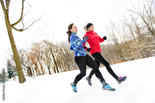 Group of friends enjoying jogging in the snow in winter