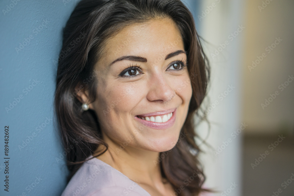 Portrait of happy young woman leaning against wall Portrait of happy young woman leaning against wall