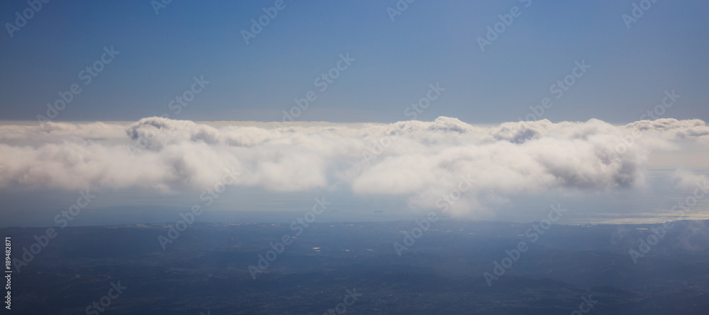 Blue sky background with clouds over landscape's silhouette. Aerial photo, panoramic, space, banner