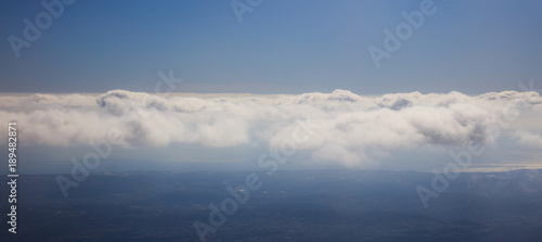 Blue sky background with clouds over landscape's silhouette. Aerial photo, panoramic, space, banner