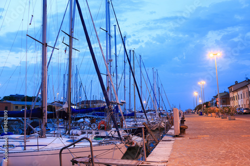 Pesaro harbour in the sunset with ancient buildings, ships, yachts. Marche, Italy
