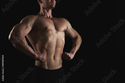 Strong athletic man showes naked muscular body