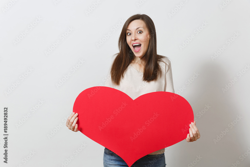 Beautiful young smiling woman holding big red heart in hands isolated on white background. Copy space for advertisement. With place for text. St. Valentine's Day or International Women's Day concept. Beautiful young smiling woman holding big red heart in hands isolated on white background. Copy space for advertisement. With place for text. St. Valentine's Day or International Women's Day concept.