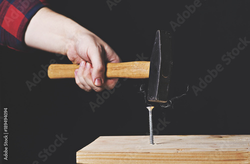 Foto hammer a screw on a black background