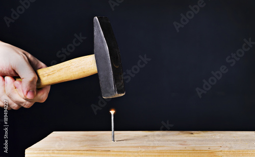 hammer a screw on a black background photo