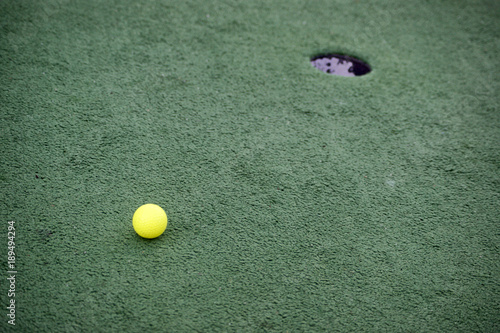 Golf ball near hole (Мяч для гольфа около лунки)