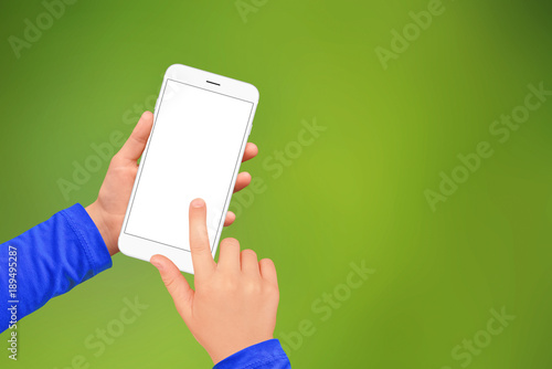 A boy using smartphone with empty screen on green blurred background. Mockup