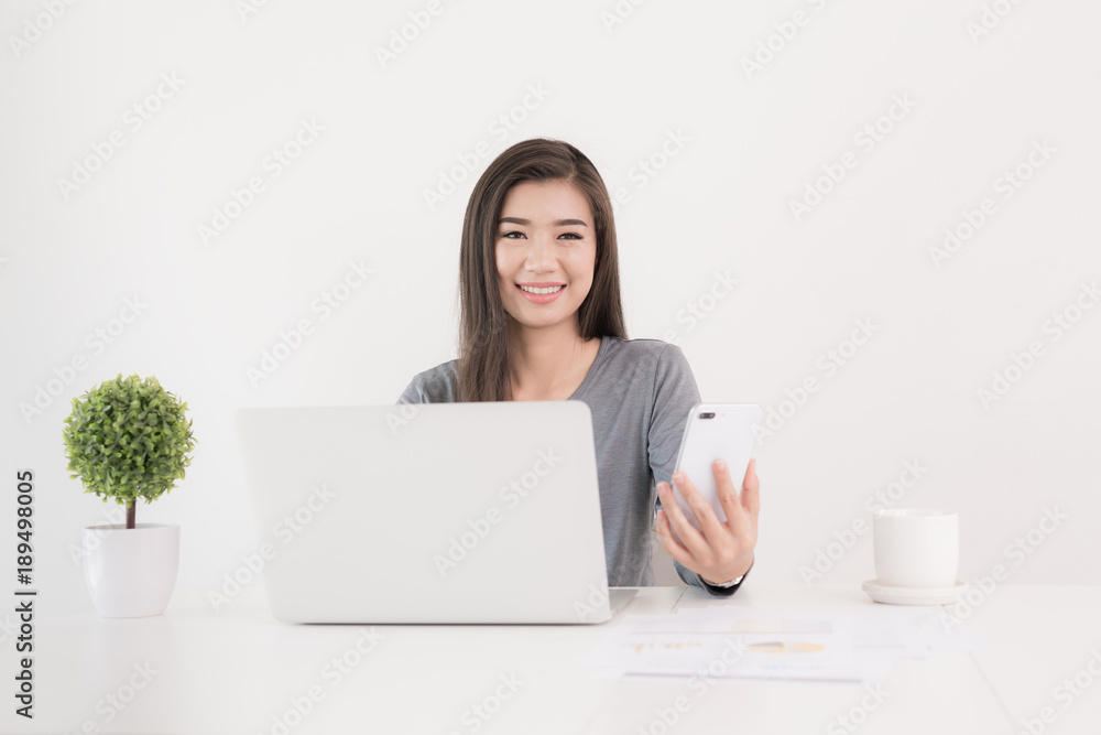 Asian woman using smartphone with notebook at office desk Asian woman using smartphone with notebook at office desk