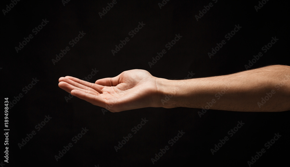 Man holding palm open isolated on black