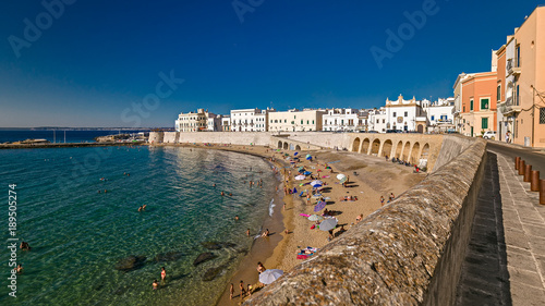 Bagers sunbathe in the beach of purity, in the historic center of Gallipoli. photo