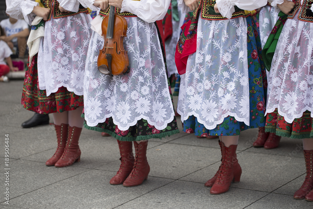 Polish folk dance group with traditional costume and a violin
