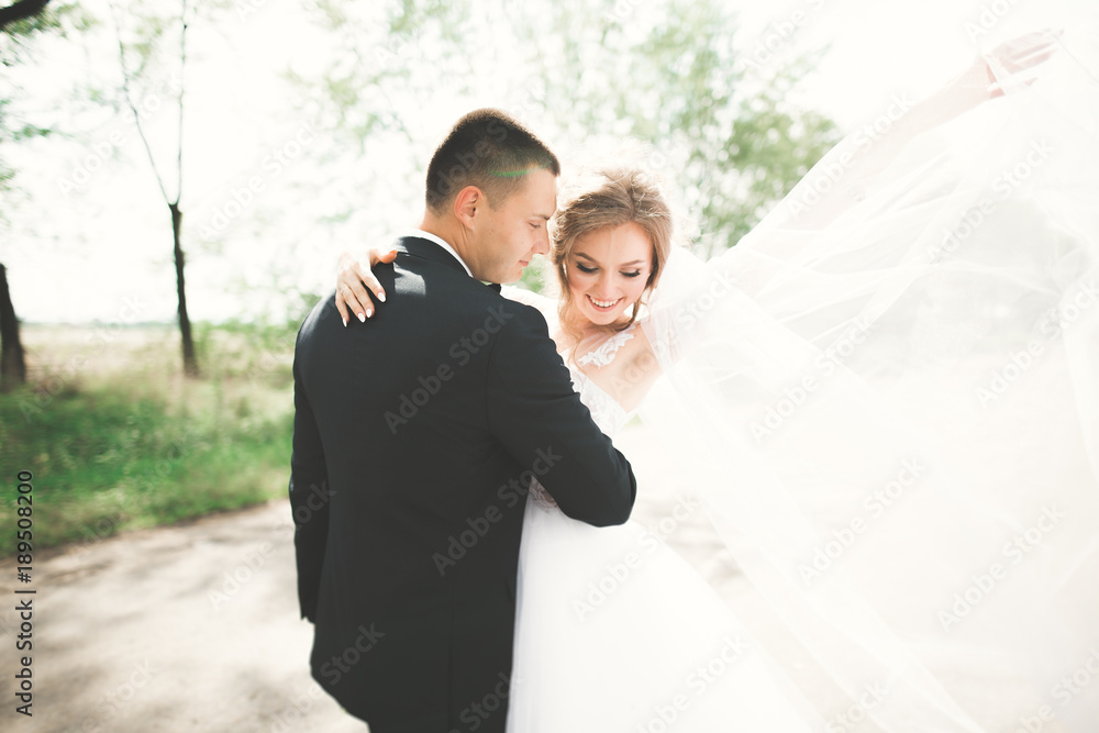Newly married couple running and jumping in park while holding hands Newly married couple running and jumping in park while holding hands