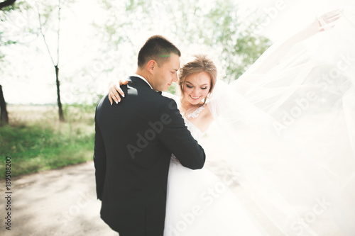 Newly married couple running and jumping in park while holding hands © olegparylyak