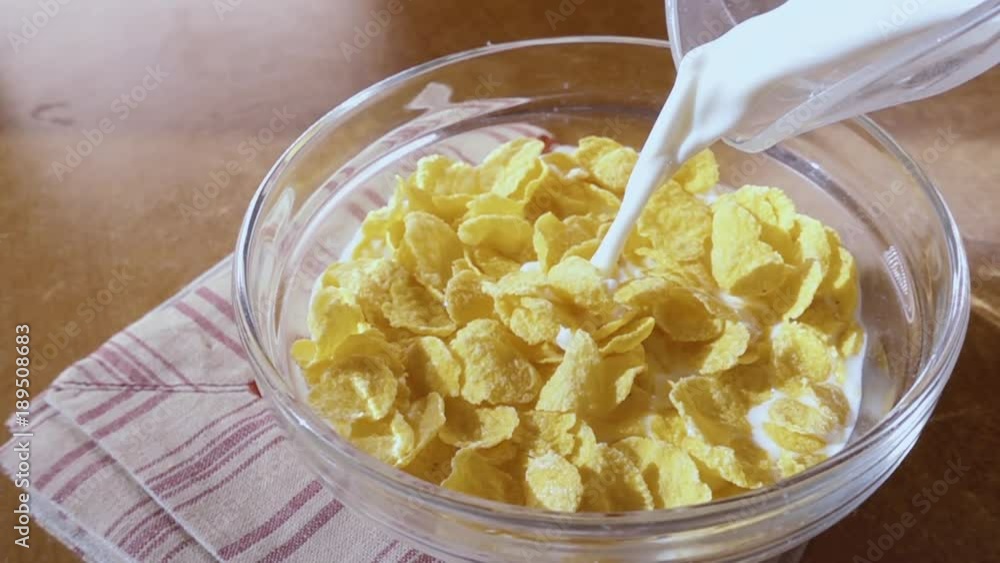 Crispy yellow corn flakes into the bowl for the morning a delicious Breakfast with milk. Slow motion with rotation tracking shot. Crispy yellow corn flakes into the bowl for the morning a delicious Breakfast with milk. Slow motion with rotation tracking shot.
