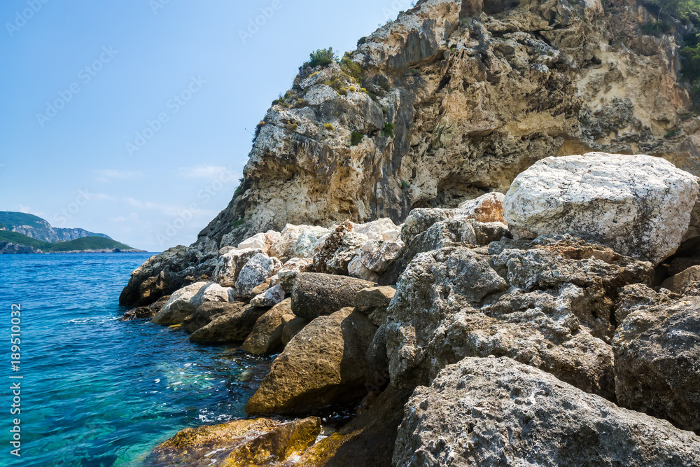 Stone rock and emerald color water of ionian sea in Paleocastritsa, Corfu, Greece.