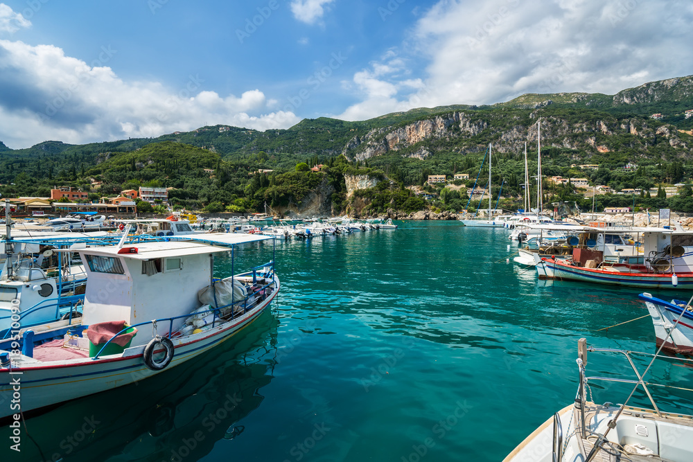 Yachts, boats and sailor ships parking in Paleokastritsa bay, Corfu, Greece.
