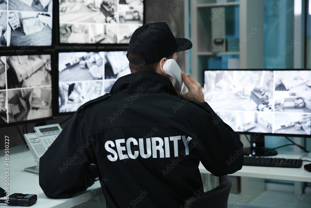 © Africa Studio - Male security guard talking by telephone in surveillance room © Africa Studio - Male security guard talking by telephone in surveillance room