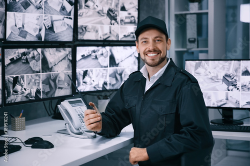 Quadro su tela Male security guard working in surveillance room