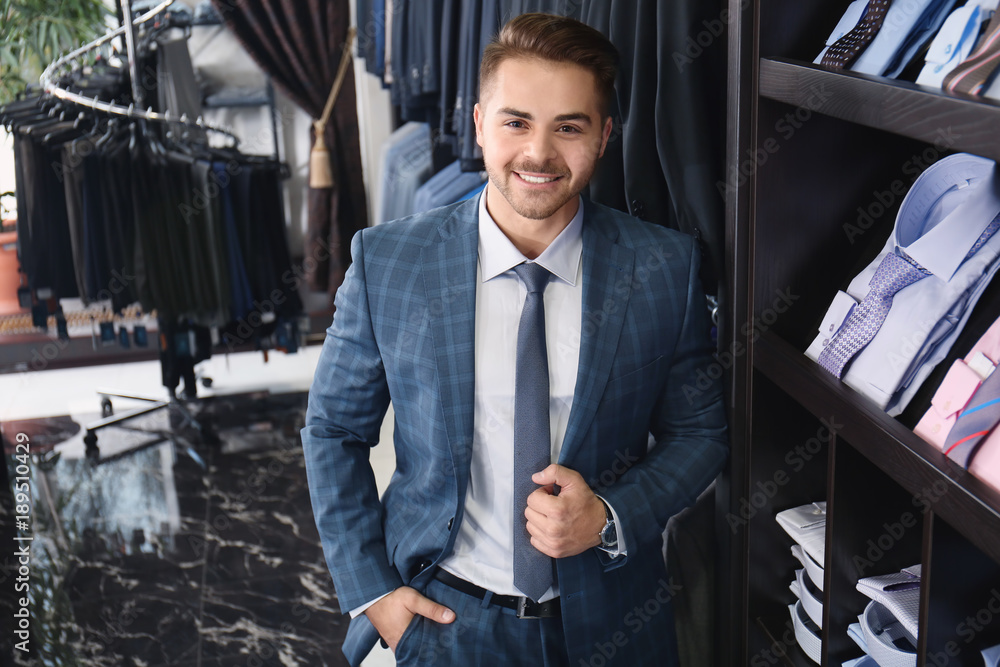 Handsome young man wearing suit in shop Handsome young man wearing suit in shop