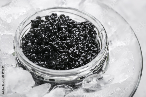 Black caviar served with ice in glass bowl