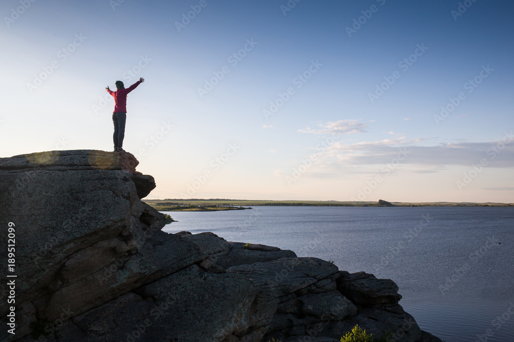 Young woman sitting on rock and enjoying beautiful view Young woman sitting on rock and enjoying beautiful view