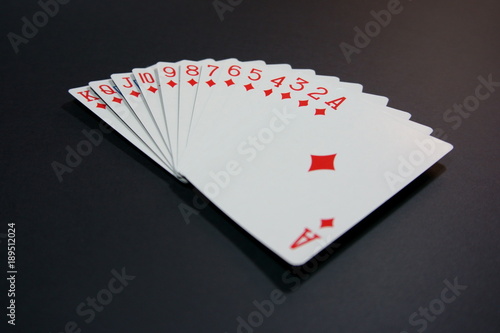 Full diamond series of playing cards on black surface