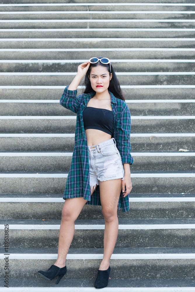 Fototapeta premium Portrait of beautiful asian woman,Hipsters girl for take a picture outdoor,Thailand people stand on stair