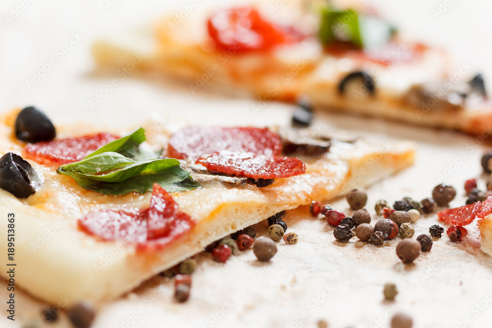 A hot pizza slice with dripping melted cheese. Isolated on white. A hot pizza slice with dripping melted cheese. Isolated on white.