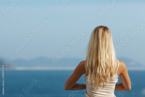 Young woman doing yoga outdoor, sea view