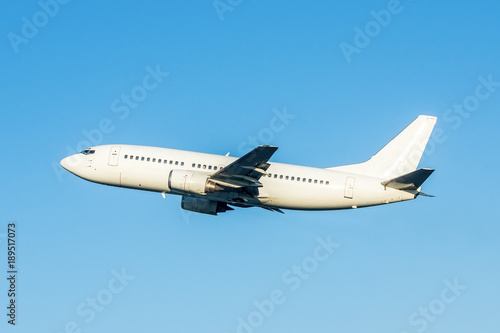 Modern white passenger airplane flying in the air.