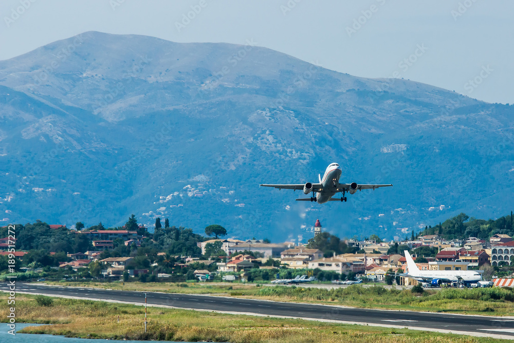 Modern twin-engine passenger airplane taking off at Corfu Ioannis Kapodistrias international airport. Modern twin-engine passenger airplane taking off at Corfu Ioannis Kapodistrias international airport.