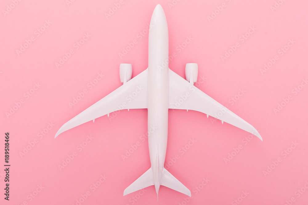White plane on light rose background. Top view White plane on light rose background. Top view