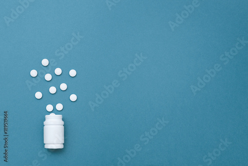 the photo of white tablets and drugs on a blue background