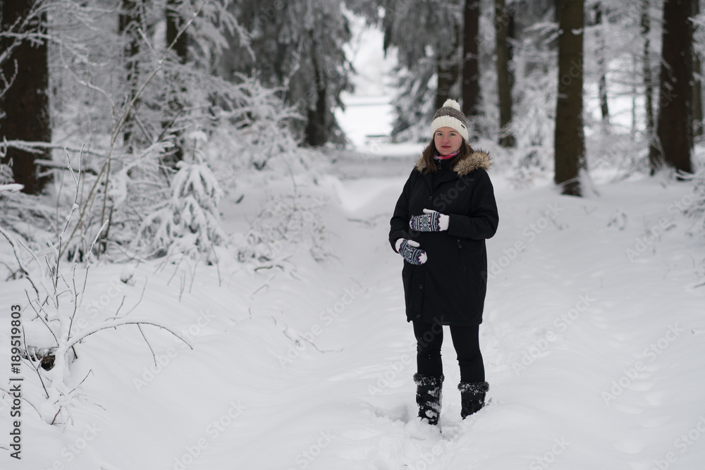 Pregnant woman a walk in winter landscape, beautiful snow-covered countryside. woman wearing black coat and winter hat.